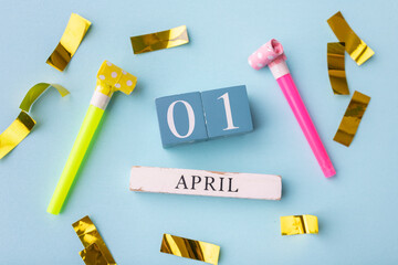 April 1st. Image of april 1 wooden calendar and festive decor on the blue background. April Fool's Day