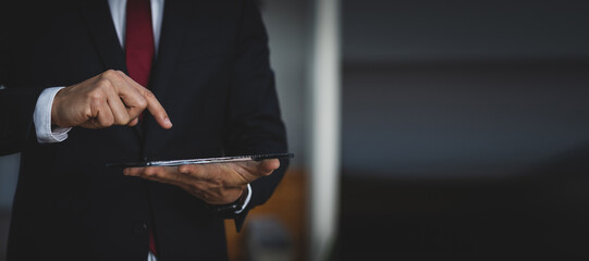 Close up of a businessman holding a tablet.