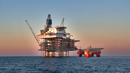 Crude oil production in the sea. View of jack up rig, semi submersible platform and supply vessel...