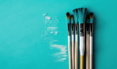  a group of paint brushes sitting on top of a blue wall next to a paintbrush with a white spot on the side of the wall.  generative ai