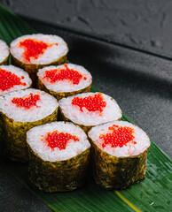 Maki Sushi with red caviar on black plate