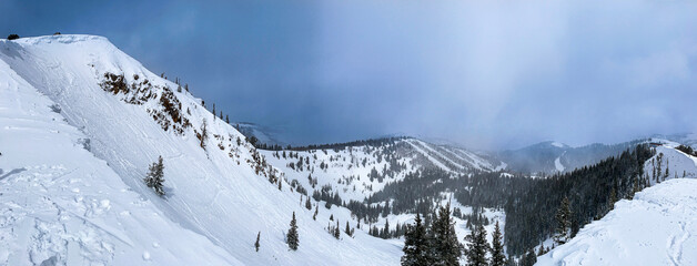 Panorama of snowy mountains of Park City ski resorts as seen from the top of McConkey's hike.