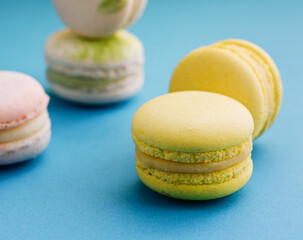Sweet and colorful macaroons on blue with yellow background