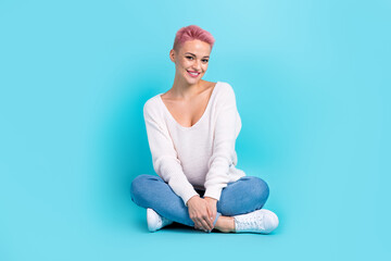 Full length photo of sitting pretty woman folded legs wear white long sleeve denim jeans lovely person posing isolated on aquamarine color background