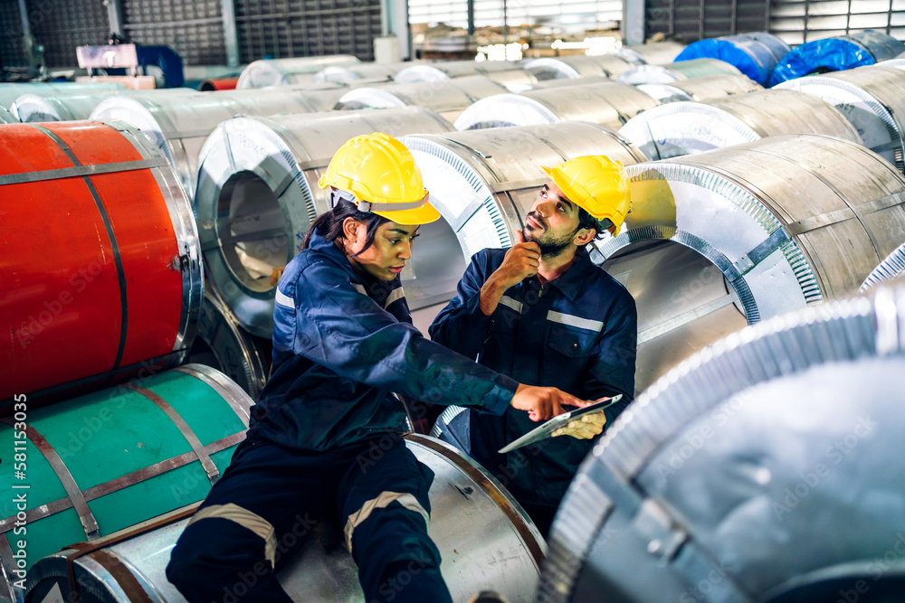 Wall mural Professional two labor machanic engineer technician worker industrial man and woman wearing safety uniform working control with heavy machine in manufacturing  factory production line