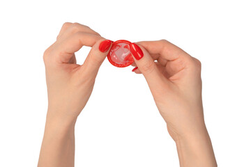 A red condom in a woman hand with red nails isolated on white background.