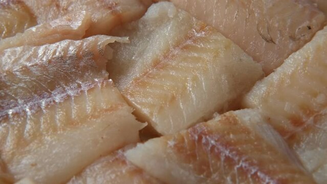 Raw fish fillet is spinning. Top view. Slices of fresh whitefish. Full frame. Sashimi rotation. Close up. Marine market. Video for sale. Cod, pollock loin steaks. Pangasius, tilapia pieces background.