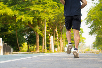 Fototapeta premium happy young Asian handsome man enjoys his running in city public park during a summer day, sporty guy spend quality time on weekend jogging outdoor in nature for healthy and active lifestyle