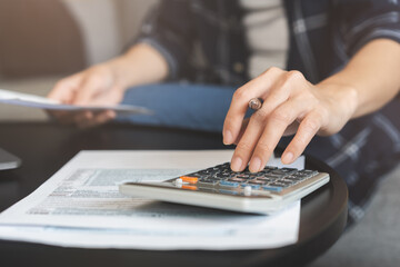 Deduction planning concept. Asian young woman hand using calculator to calculating balance prepare tax reduction income, cost budget expenses for pay money form personal Individual Income Tax Return. - obrazy, fototapety, plakaty