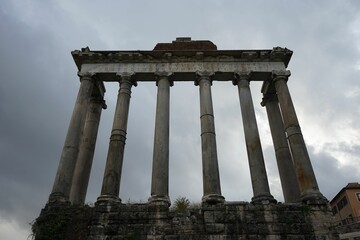 Low angle shot of the ruins of the Temple of Saturn in Rome, Italy, with clouds in the background