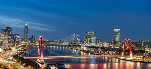 Skyline of Rotterdam at night over the river Maas showing the Willems bridge and the Erasmus bridge