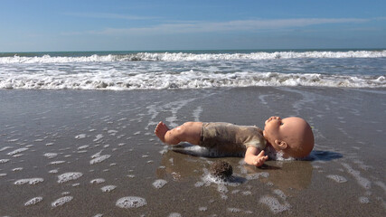Children's toy by the sea. Refugee problem. Concept of shipwreck of migrants with their children in...