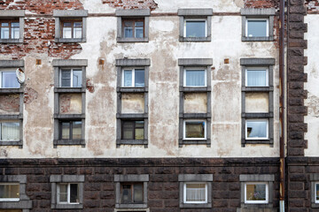 A fragment of the glass and sandstone facade of a modern office building. Wide abstract fragment of modern building facade. View of modern glass and stone facade. Panel houses built in the seventies