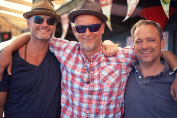 Obraz premium Carnival reunion. Portrait of three male friends at a carnival.