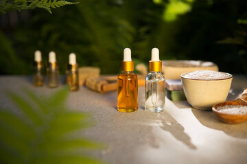 Spa still life with Natural Serums in glass bottle, salt, massager, brush for a body, olive oil...