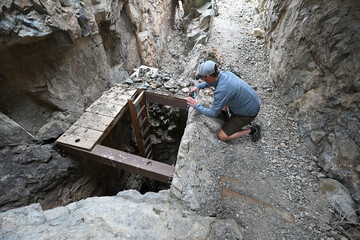 Person taking picture of vertical mine shaft.
