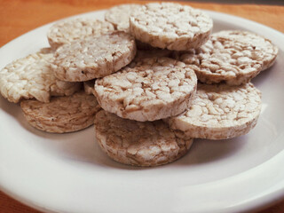 close up of plate with round rice cake Wholegrain at on orange background