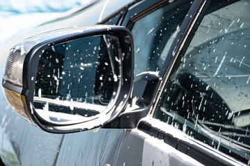 Washing  a  silver  car  with  pressure  washer  suds  and  a  cloth 