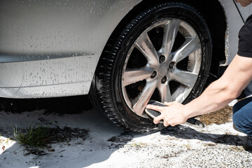 Washing  a  silver  car  with  pressure  washer  suds  and  a  cloth 