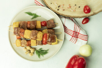 Fried meat and vegetables on wooden skewers