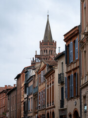 Fototapeta na wymiar Clocher de la Basilique Saint-Sernin vue depuis la Rue du Taur à Toulouse