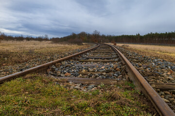 A landscape traversed by a monorail. There are heavy dark clouds in the sky.