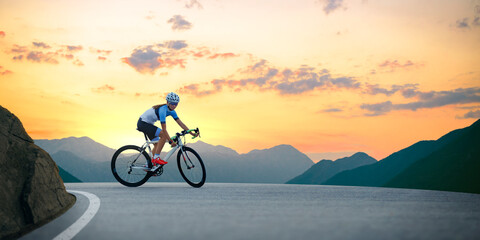 Fototapeta na wymiar Woman Cyclist Riding Road Bike in the Beautiful Mountains at Sunset. Adventure, Healthy Lifestyle, Sport