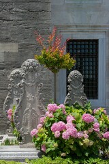 Vertical shot of a park with hydrangea flowers and old stone sculptures on a sunny day