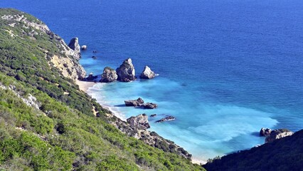 Beautiful view of Ribeiro do Cavalo Beach with rock formations in the sea in Portugal
