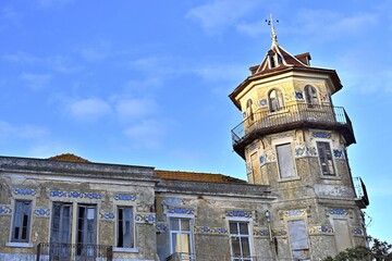 Fototapeta na wymiar Octagonal tower with four floors, tiled friezes on facades, balconies and wrought iron railings.