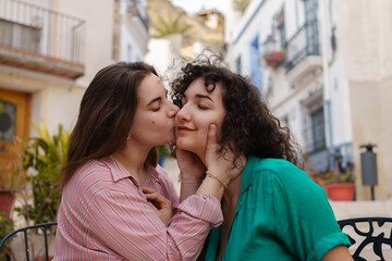 Naklejka premium two enamored lesbian girls drink coffee happily on gay pride day