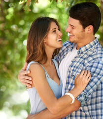 Obraz premium Making each other laugh is so important. Cropped view of a happy young couple standing together out in the park.