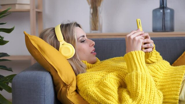 Smiling woman listening to music in living room