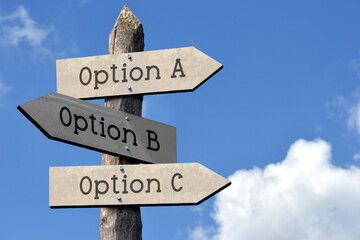 Option A, B or C - wooden signpost with three arrows, sky with clouds