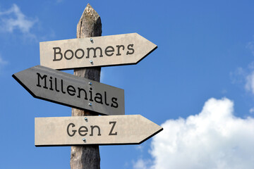 Boomers, Millenials, Gen Z - wooden signpost with three arrows, sky with clouds