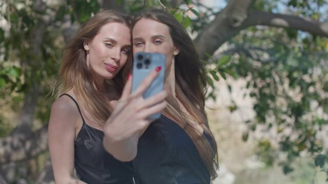 Identical twins with mobile phone for selfies