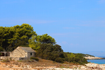 Traditional stone house and wild beach on Proizd, small island near Vela Luka, Croatia. 