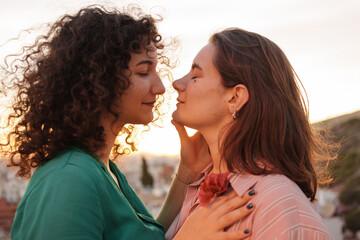 two lesbian girls in love watch the sunset on gay pride day