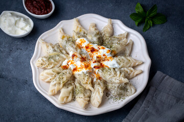 Traditional manti food on plate, top view. The concept of oriental cuisine. Uzbek food manty dumplings. (Turkish name; hinkel mantisi + cecen mantisi)