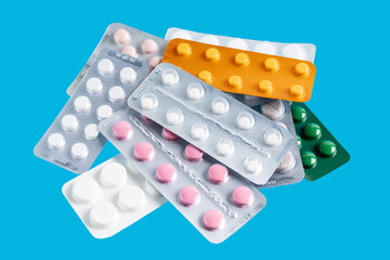 Pile of various pills and tablets in a blister packs on blue background, healthcare and medicine...