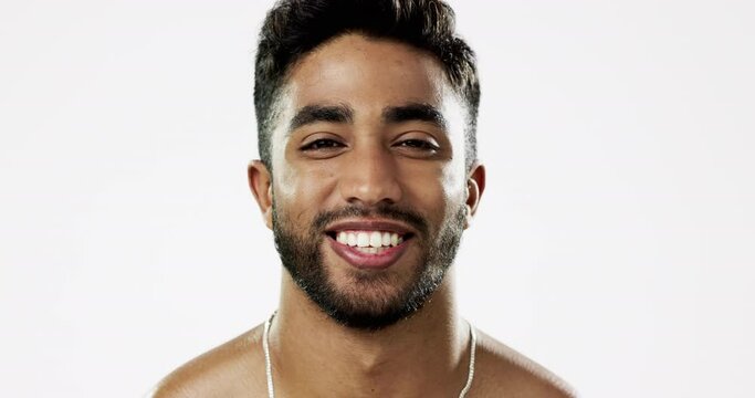 Face, smile and man in studio for skincare, happy with a beard against white background. Cheerful, glowing skin and portrait of Indian male model enjoying luxury, beauty or cosmetic care isolated