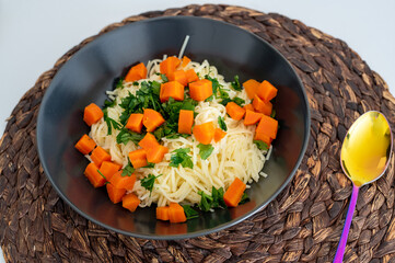 Makaron nitki z warzywami na talerzu do niedzielnego rosołu.