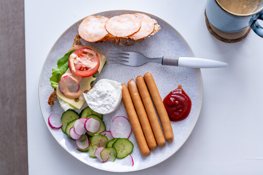 Śniadanie z par&oacute;wkami pieczywem wędliną i warzywami.