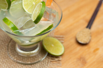 brazilian drink (caipirinha) on the wooden  table with ingredients in a sunny day
