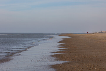 Water floating slowly onto the sandy beach on the dutch part of the North sea, silence, recreation and relaxation