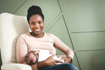 A black woman breast feeding her child girl at home