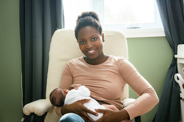 A black woman breast feeding her child girl at home