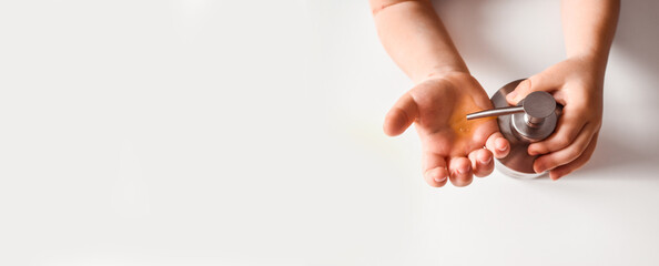 The child holds a dispenser with soap. Children's hands. Kid. Disinfection. Coronavirus Prevention