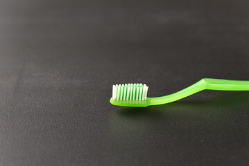 green toothbrush against a light background.