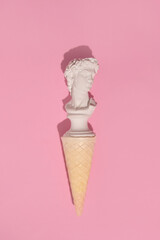 Male plaster bust, popular Italian souvenir in an ice cream cone, summer holidays, creative aesthetic layout. 
